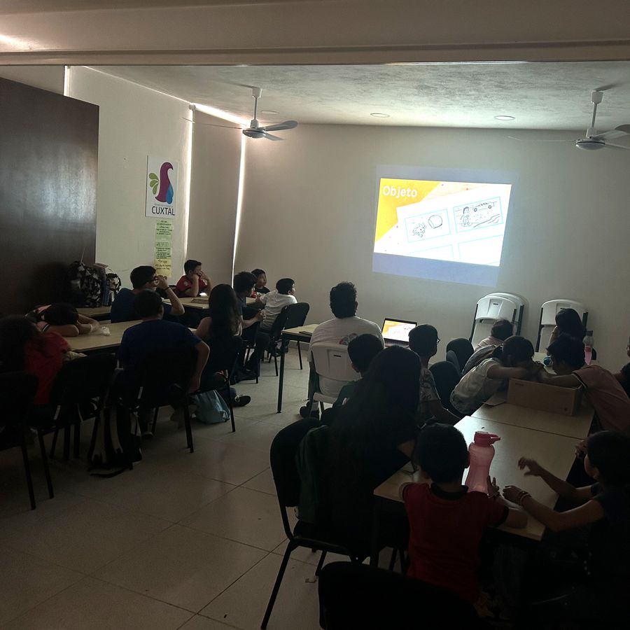 Niñas y niños viendo una proyección durante una sesión de introducción al cine