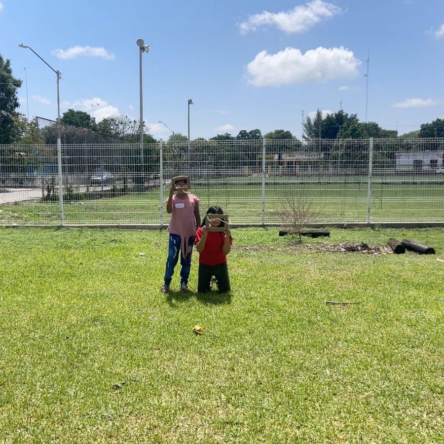 Dos niños jugando en el pasto durante un receso del taller