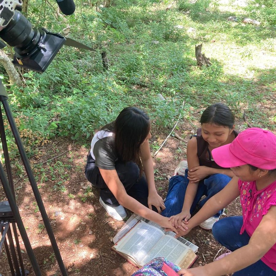 Niñas tomadas de las manos junto al equipo de cámara durante una dinámica