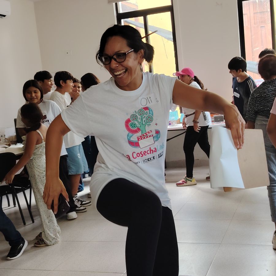 Mano sosteniendo un reconocimiento del laboratorio con participantes de fondo